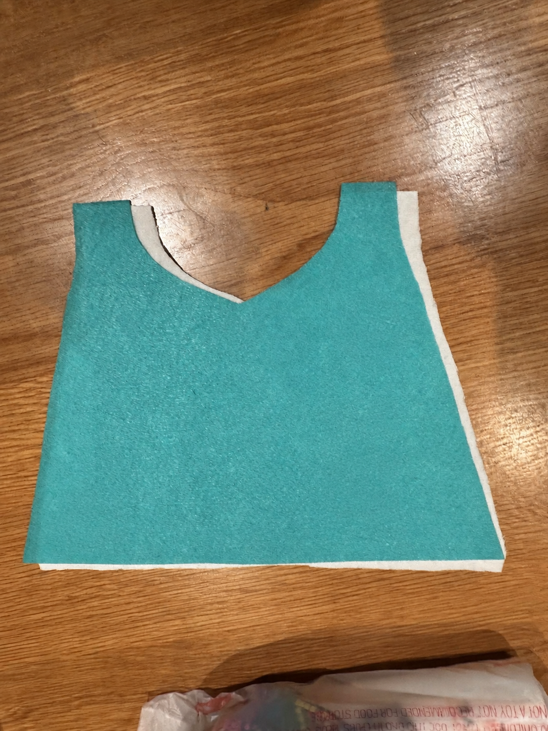 Two cape-shaped material layers before the sensory pieces and zipper were attached